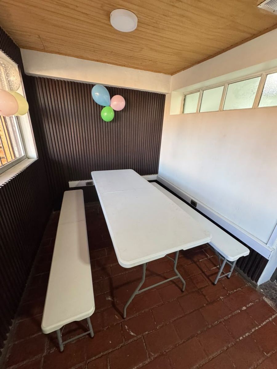 Comedor con mesa, bancas y globos para el cumpleaños