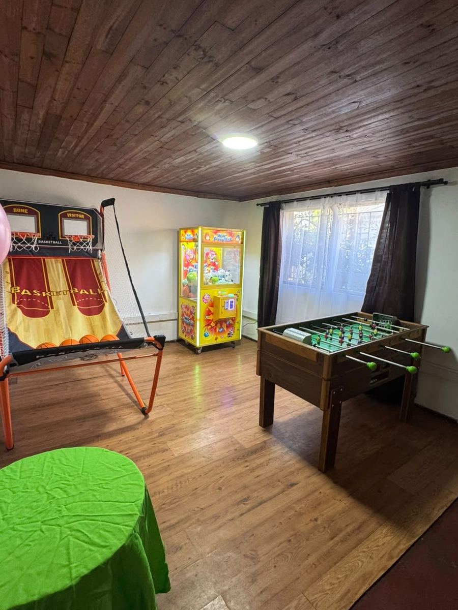 Sala de juegos con basketball electrónico, taca-taca y máquina de peluches