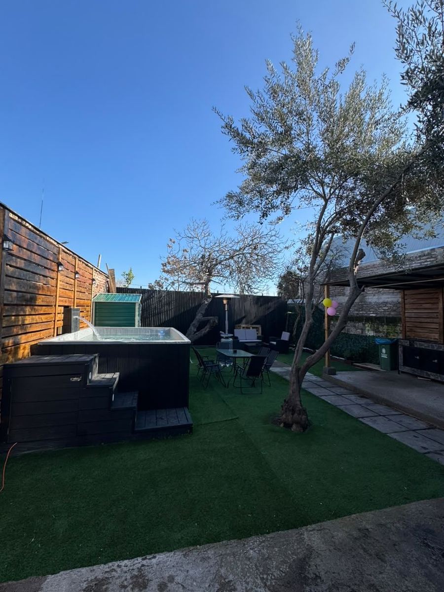 Patio con pasto, olivo y piscina con cascada