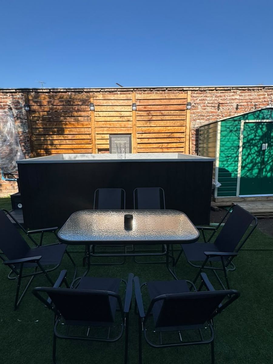 Terraza del patio con mesa y sillas junto a la piscina